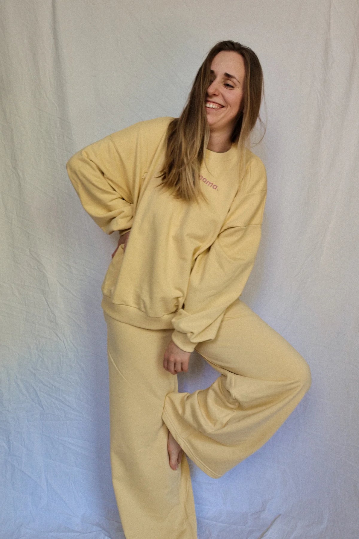Uśmiechnięta kobieta w bananowej bluzie oversize Melanie mama. i szerokich spodniach dresowych w tym samym kolorze