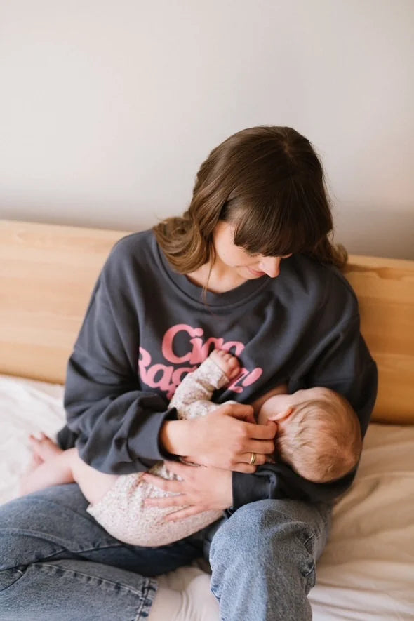 Mama w antracytowej bluzie do karmienia Melanie z różowym napisem Ciao Ragazza karmi piersią niemowlę