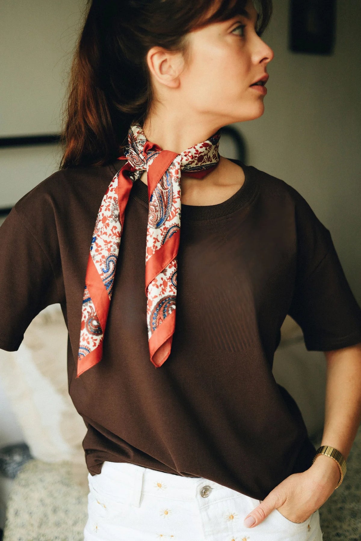 Kobieta w czekoladowym t-shircie do karmienia Helen i apaszce w paisley patrzy w bok